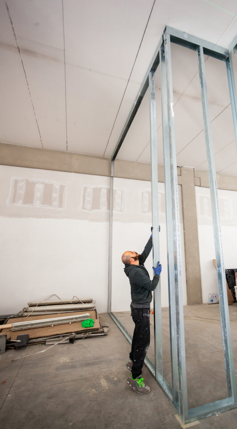 Worker at work in the construction of a plasterboard wall.