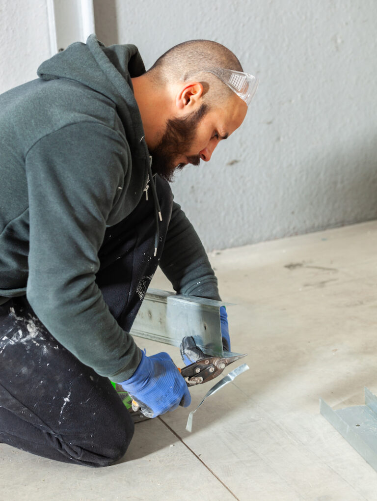 Worker at work in the construction of a plasterboard wall.